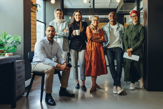 Group of diverse businesspeople smiling at the camera in an office.