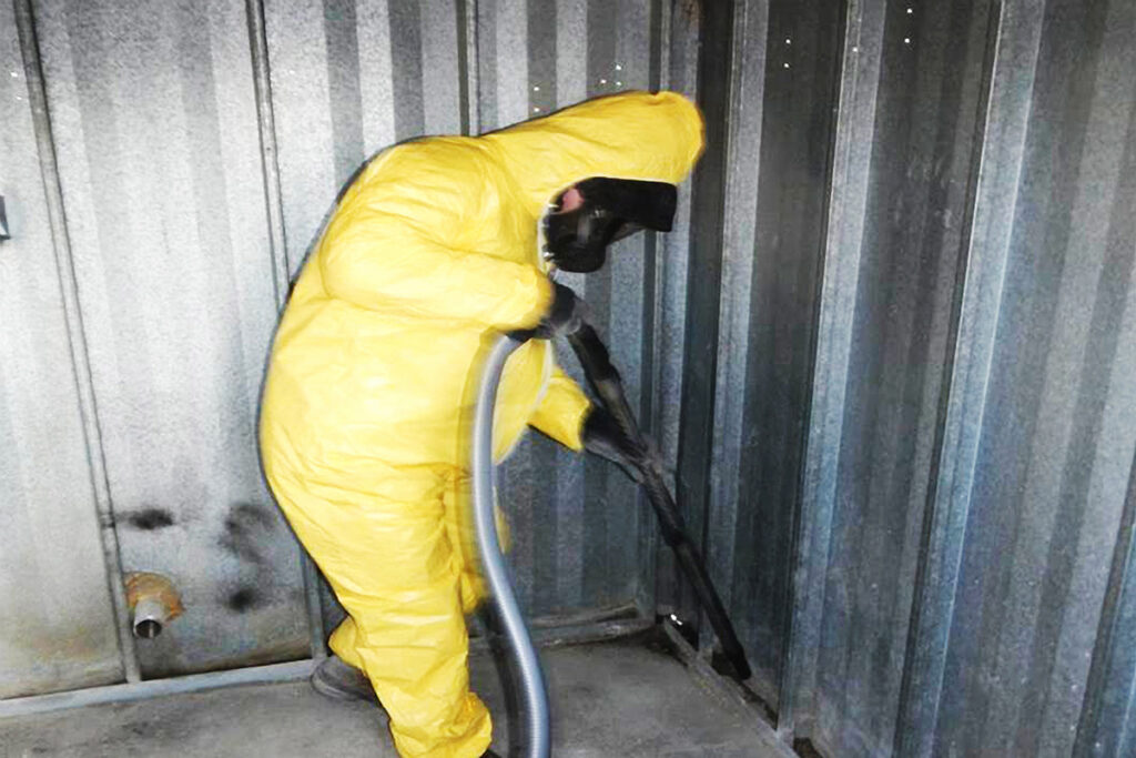 Worker cleaning lead impacted dust