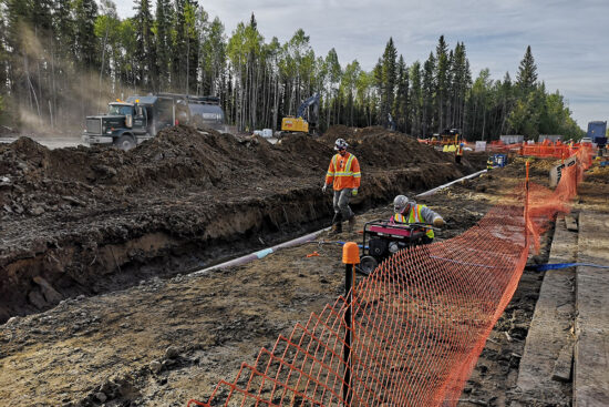 Workers installing pipe sections