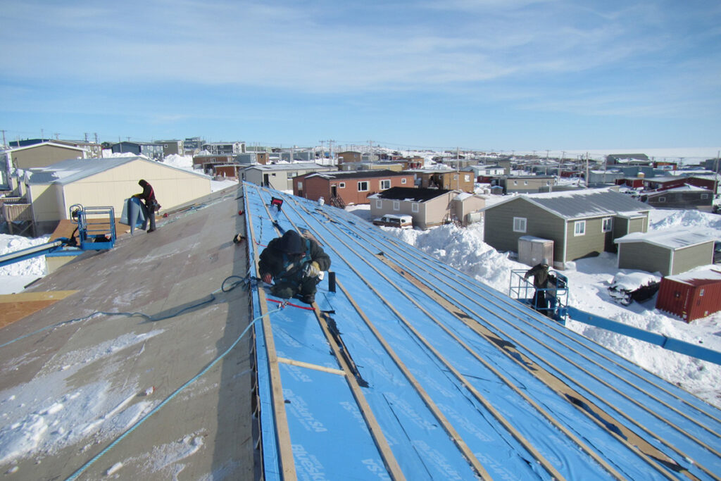 Workers fixing roof of building in Baker Lake