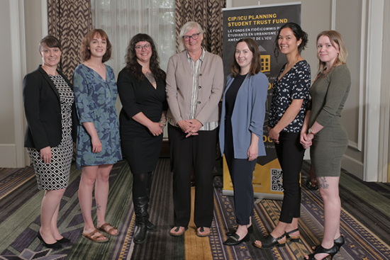 Group of women in front of a banner for a planning conference event